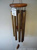 Full view of the Woodstock Chimes of Jerusalem wind chime showing the wooden top and bronze aluminum tubes hanging evenly spaced.