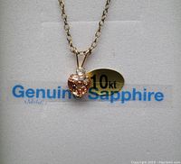 Pendant and chain displayed with 10 KT and Genuine Sapphire label visible.