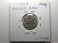 Image of 1904 USA Barber Dime silver coin in protective holder, showing reverse side with 'ONE DIME' inside a wreath.