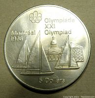 Obverse side showing Montreal Olympics design with sailboats, 5 Dollar denomination, and inscriptions including 'Montreal 1976' and 'Olympiade XXI Olympiad'.