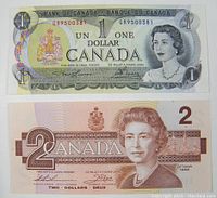 Front sides of the 1973 one dollar bill and 1986 two dollars bill showing Queen Elizabeth II portraits and text.