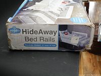 Box showing Regalo HideAway bed rails branding and dimensions on the side panel.