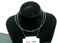 Chain necklace displayed on a black velvet stand, showing full length and clasp.