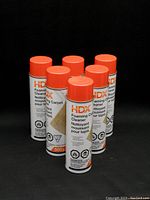 Six cans of HDX Foaming Carpet Cleaner arranged together showing front labels with orange caps