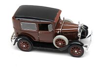 Left side view showing two-tone brown and black paint with dual spare tires and detailed trim.