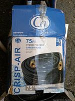 Box front showing CRISP-AIR branding, product length 75ft, hybrid polymer material, and product details with brass connectors visible through packaging.