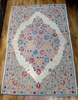 Full front view of rectangular carpet with floral medallion and border patterns.