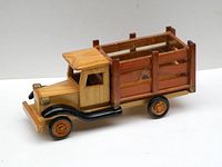 Side view showing wooden stake bed truck with natural wood finish and black fenders and wheels.