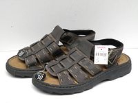 Side view of brown leather sandals showing stitching and thick sole.