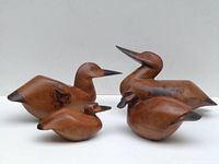 Four handcrafted wooden duck figurines showing varied shapes, body contours, and painted details.