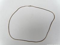 Photo of the sterling silver chain necklace laid out flat in a loop shape, showing the full length and simple clasp.