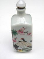 Front image of white porcelain snuff bottle with hand-painted cranes and plum blossom branch.