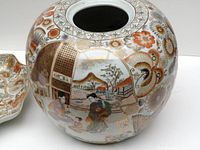 Close-up of the rounded jar showing detailed hand-painted floral and scenic Japanese design in orange and gold highlights
