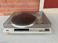 View of turntable with dust cover closed, showing overall form and condition.