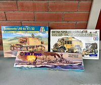 Three vintage military model kits in their original boxes. Italeri Semovente L40 tank, Tamiya Canadian Ford F.G.T. truck with artillery, and Airfix H.M.S. Hood battleship.