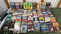 Full collection of approximately 45 mystery and science fiction paperback books including multiple titles by Edgar Rice Burroughs, Star Trek novels and other sci-fi authors arranged on a flat surface.