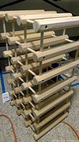 Full view of the solid oak wine rack showing multiple tiers and horizontal rods for bottle storage.