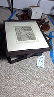 Framed etchings stacked showing one print with ears of wheat and visible artist signature and numbering