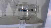 Photo of vintage Pyrex percolator coffee pot fully assembled showing the clear glass pot, handle, and lid with metal band around the top