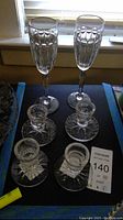 Photo showing two Waterford crystal champagne flutes and four crystal candle holders item arrangement.