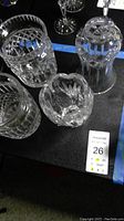 Three Waterford crystal biscuit barrels without lids and one Waterford crystal vase, with all showing detailed cut crystal patterns.