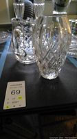 Two clear crystal Waterford pieces, a vase and a pitcher, showing intricate cut designs and clear glass brilliance.