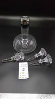 Full set showing Menu decanter and three crystal wine stoppers on black background