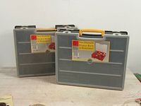 Two Holt brand double sided pack organizers with yellow handles, closed, showing front labels.