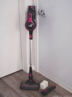 INSE N5 vacuum standing upright assembled with extension wand and motorized brush head, plus small brush and white adapter on floor.