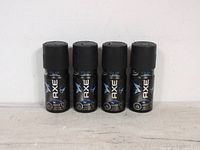 Four Axe CLIX body spray cans with black and blue design and black caps.