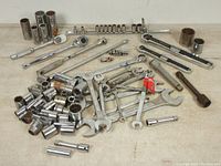 Full lot showing all items including ratchets, wrenches, sockets, and extensions spread out on a white surface.
