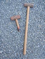 Photo of both sledge hammers lying on gravel ground showing full length and relative size