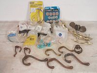 Vintage hardware including coat hooks, drawer pulls, cabinet knobs, some new in packaging and some lightly used