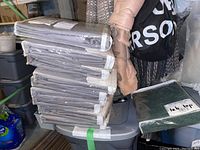 Stack of nine twin curtain panels 42x95 inches wrapped in plastic with grey herringbone fabric pattern.