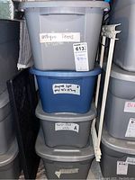 Photo of stacked bins labeled antique linens, light grey drapes, twin flat white, and more