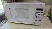 Full front view of white Toastmaster microwave with keypad and digital display.