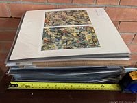 Stack of multiple matted and sealed prints approximately 12 inches wide