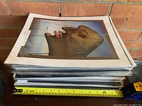 Stack of twelve matted prints sealed in plastic sleeves
