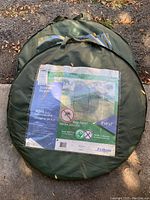 Two green carrying cases for collapsible hexagonal screen rooms, label showing product details and size 8'x8'x7'