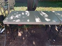 Top view of the white rectangular plastic table surface with visible shadows and some scratches.