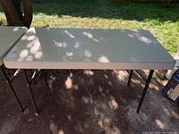 Full view of the beige plastic tabletop with some sunlight and shadows showing surface condition.
