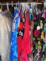 Hanging women's bathing suits showing variety of colors and patterns including blue, red, animal print, and florals.