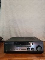 Front view of Kenwood KR-V6060 audio/video stereo receiver showing controls, display, and power button.