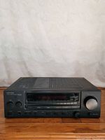 Front view of Kenwood KR-694 stereo receiver showing control knobs, tuning dial, and frequency display.