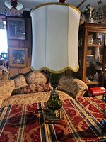 Full view of the vintage Murano glass table lamp on a patterned cloth background, showing total height and shade shape.