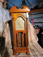 Full view of vintage United Electric mini mantel clock showing wooden case, decorative columns, brass accents, and pendulum visible through glass panel.