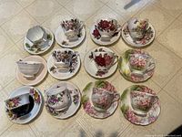 All teacups and saucers arranged on floor showing floral patterns and colors
