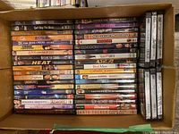 Overhead wide shot of a boxed collection of DVDs organized in rows showing titles and spines.