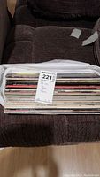 Photo of 24 LP vinyl records stacked in a plastic sleeve showing spines with titles and visible wear.
