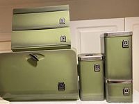 Overall view of all items together showing the bread box and the four labeled canisters in avocado green with chrome accents.